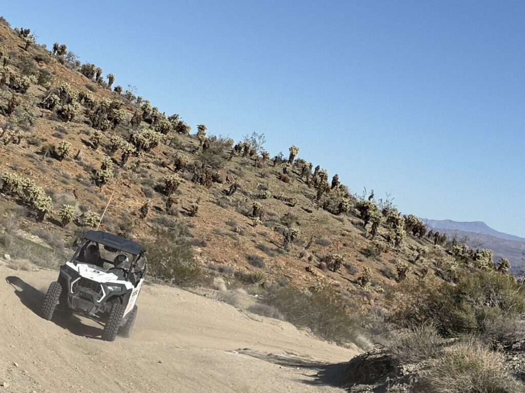 A white off-road vehicle explores a dusty Nevada trail near the Colorado River by Las Vegas, perfect for RZR rides and ATV tours.