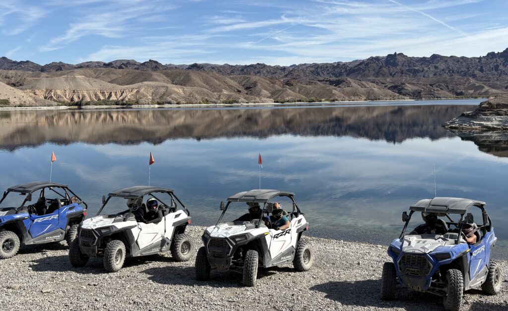 ATVs and RZRs parked lakeside near the Colorado River, Nevada—Las Vegas off-road adventure tours with desert mountain views.