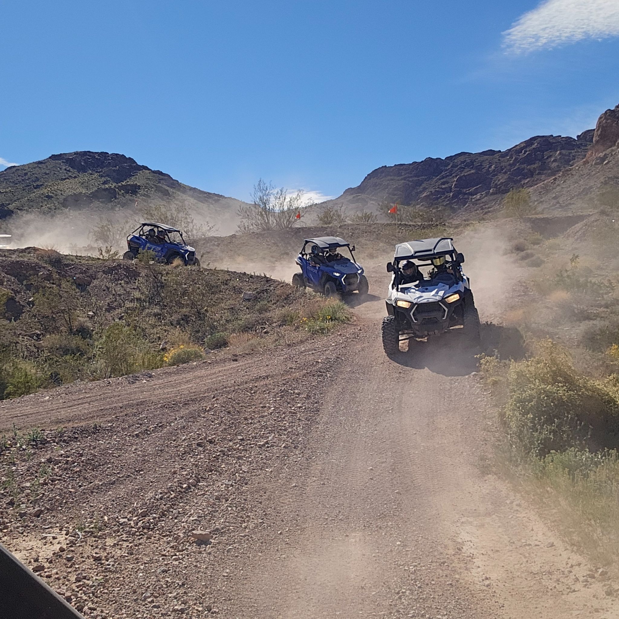 Blue off-road vehicles on a dusty Nevada desert trail near Las Vegas, ideal for RZR ATV tours and Colorado River adventures.